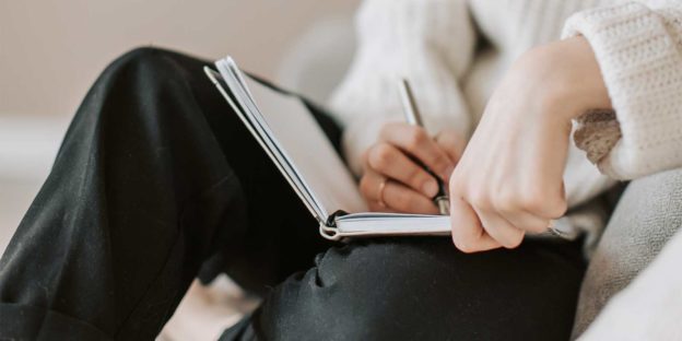 Stockfoto van iemand die in agenda schrijft