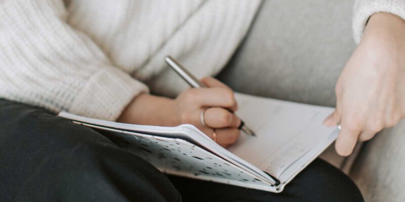 Stockfoto van iemand die in agenda schrijft